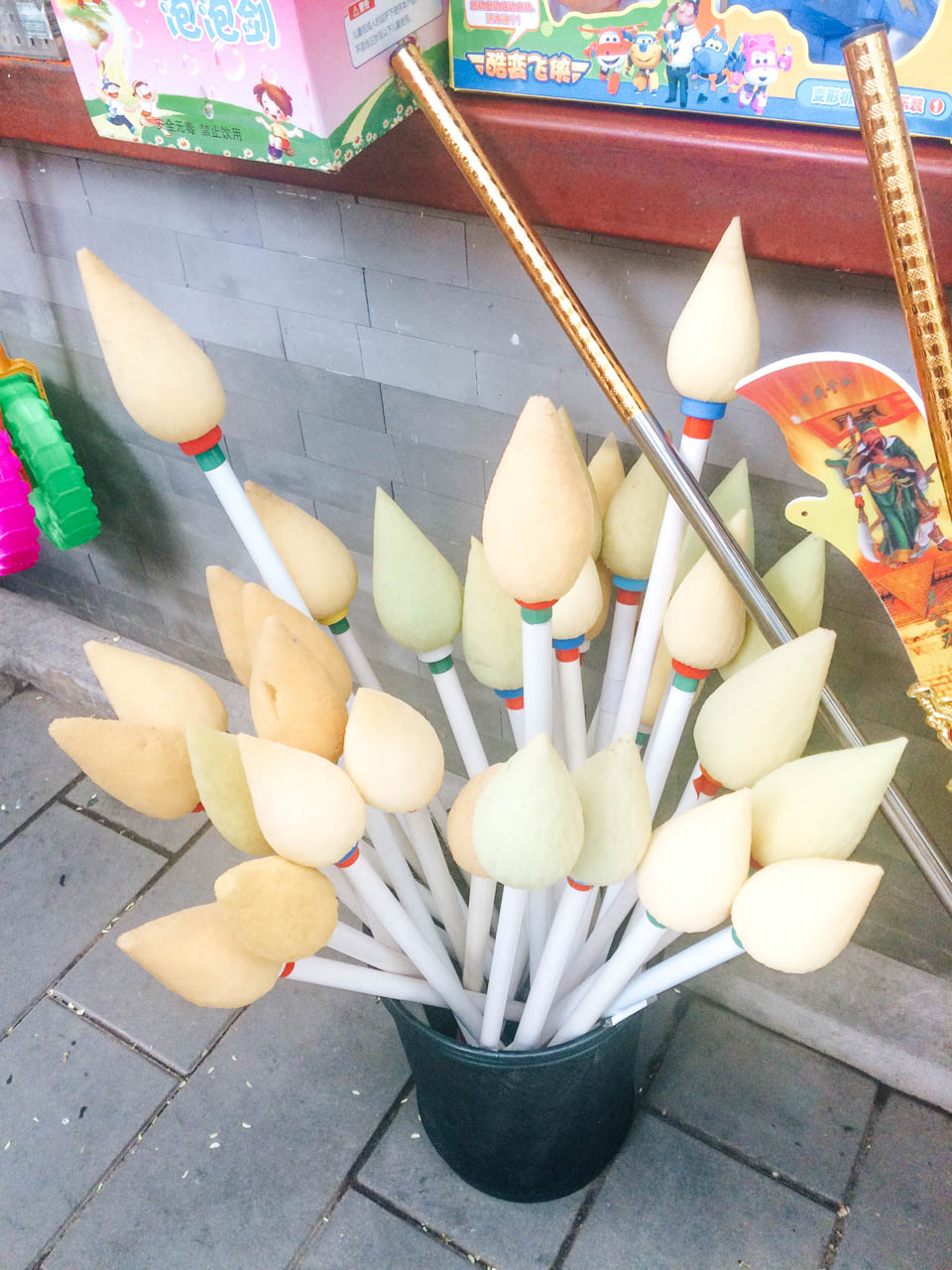 A bucket filled with giant brushes for water calligraphy