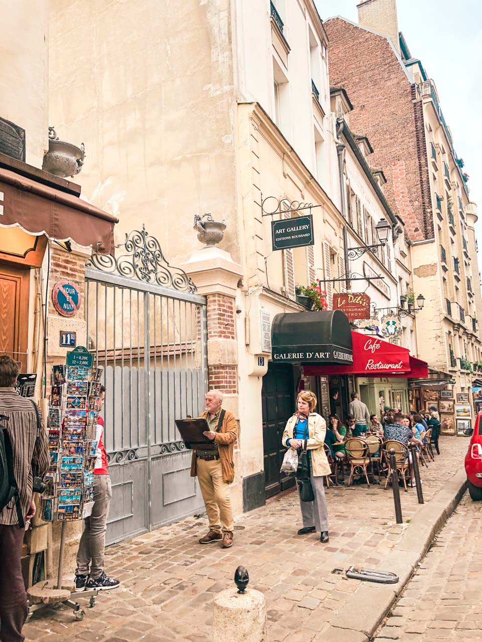 Woman standing next to a street artist painting a portrait of a young man in Montmartre