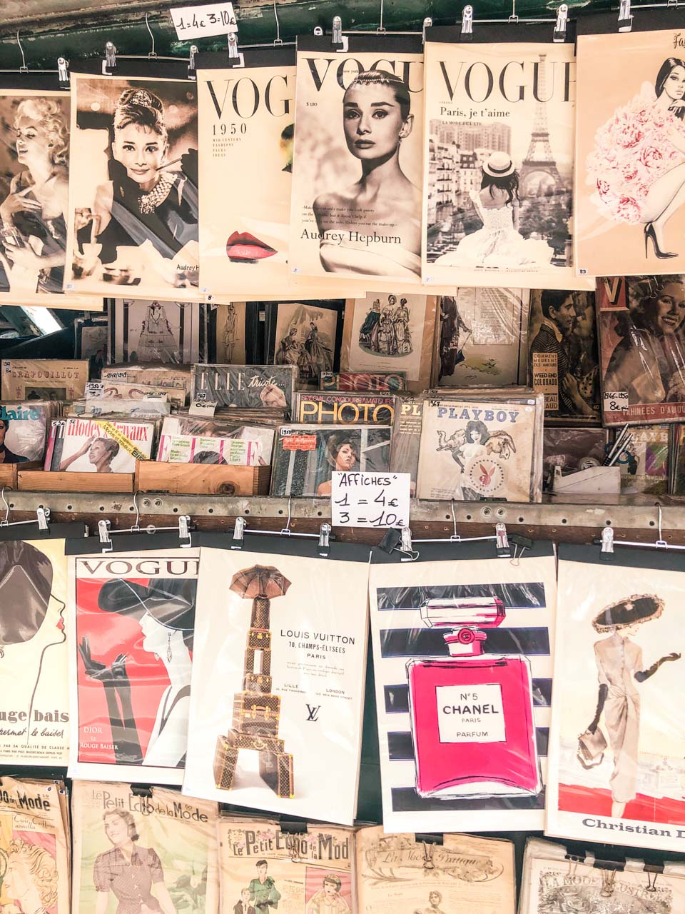 Vintage posters and Vogue covers at a bookstall near the Quai des Grands Augustins in Paris, France