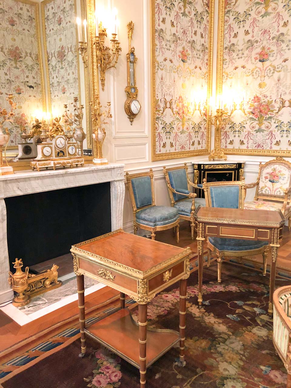 Baroque wallpapers, wooden cabinets and blue upholstered furniture in the Louvre Museum