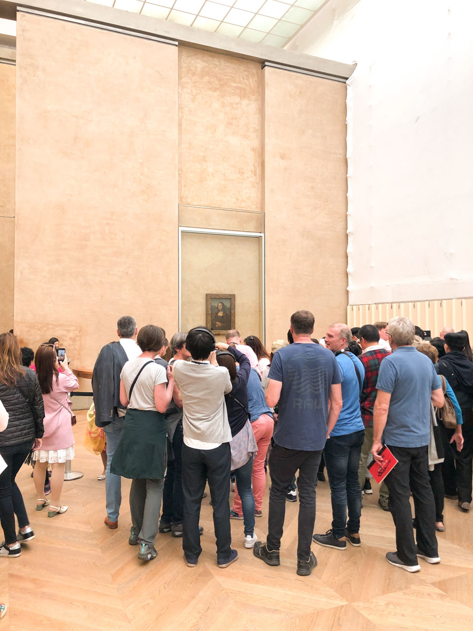 Crowds of people gathered around the Mona Lisa painting by Leonardo da Vinci at the Louvre