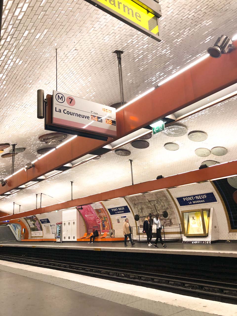 People walking on the platform at the Pont-Neuf La Monnaie metro station in Paris, France