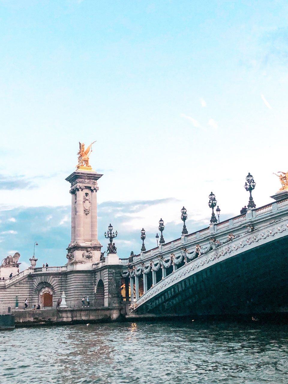 A close-up shot of the Pont Alexandre-III bridge in Paris, France seen from a cruise boat