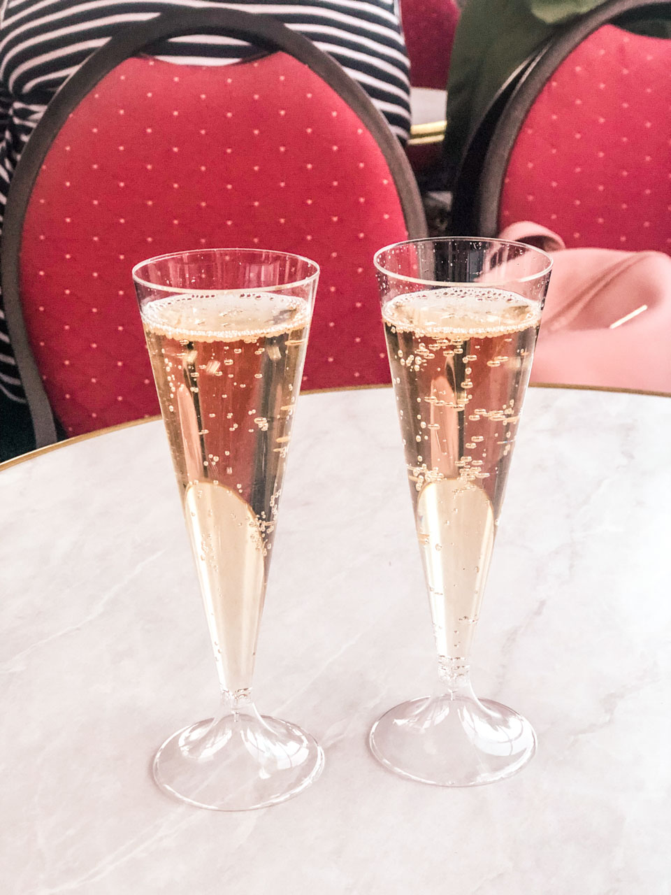Two plastic champagne flutes on a table on board of a cruise boat on the Seine River in Paris