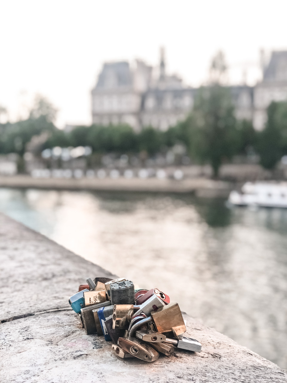 A close-up shot of various padlocks on the ledge of a bridge in Paris, France