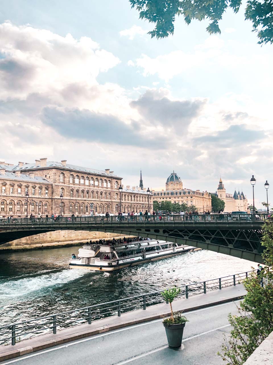 A cruise boat passing under a bridge in Paris, France