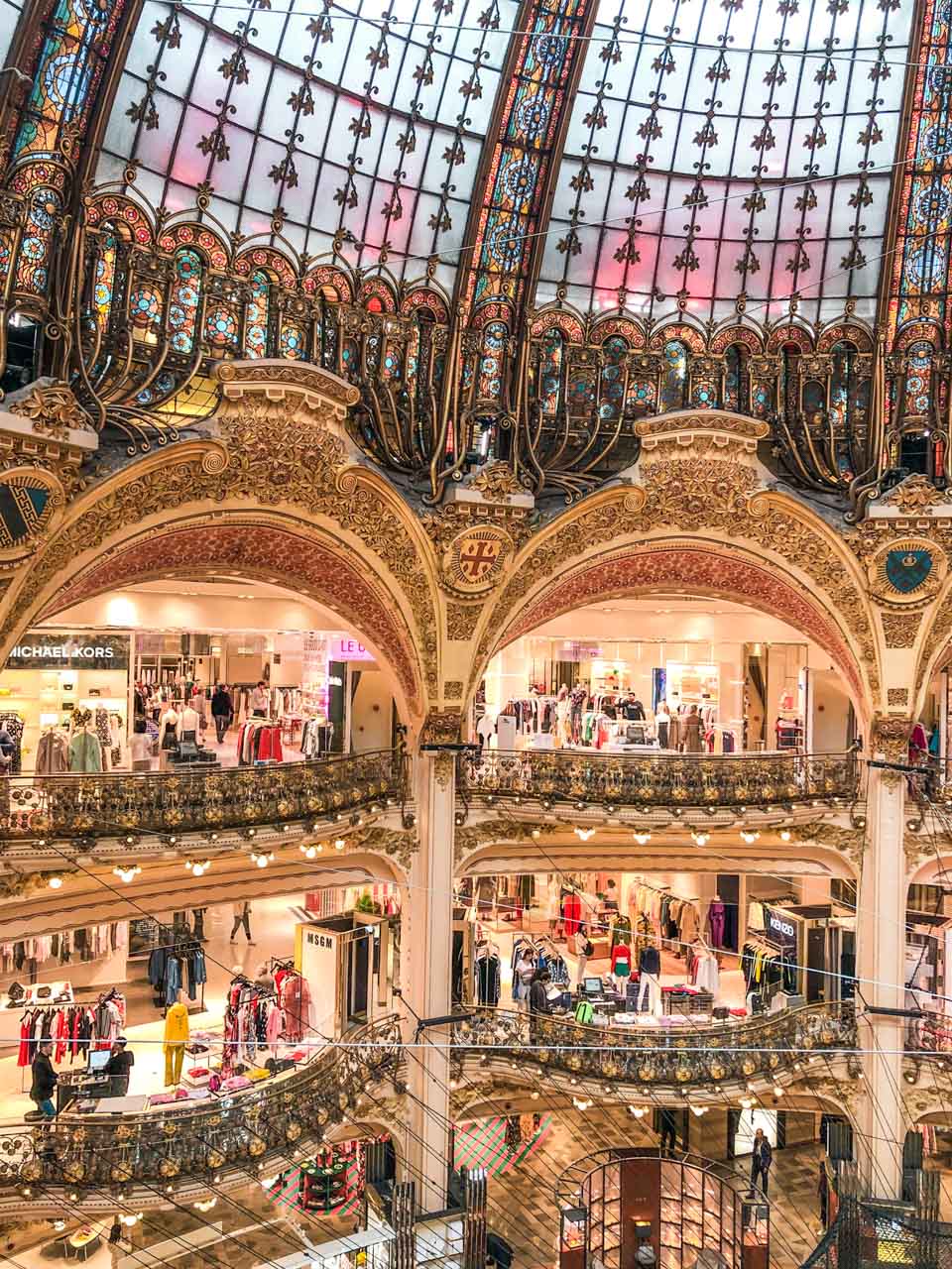 Shops inside loggias formed by ornately decorated golden arches at Galeries Lafayette Paris Hausmann