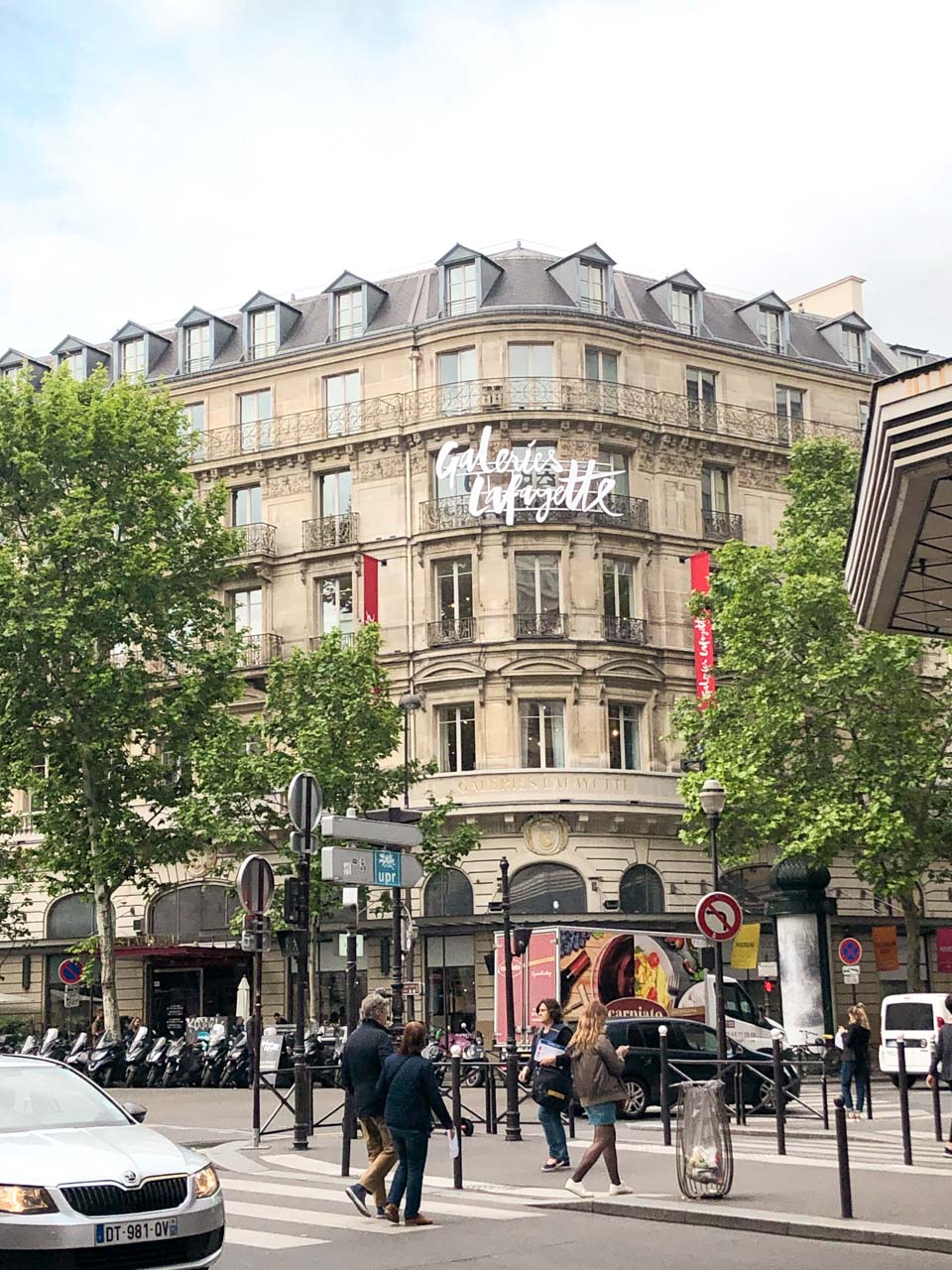 People crossing the street outside Galeries Lafayette Hausmann in Paris, France