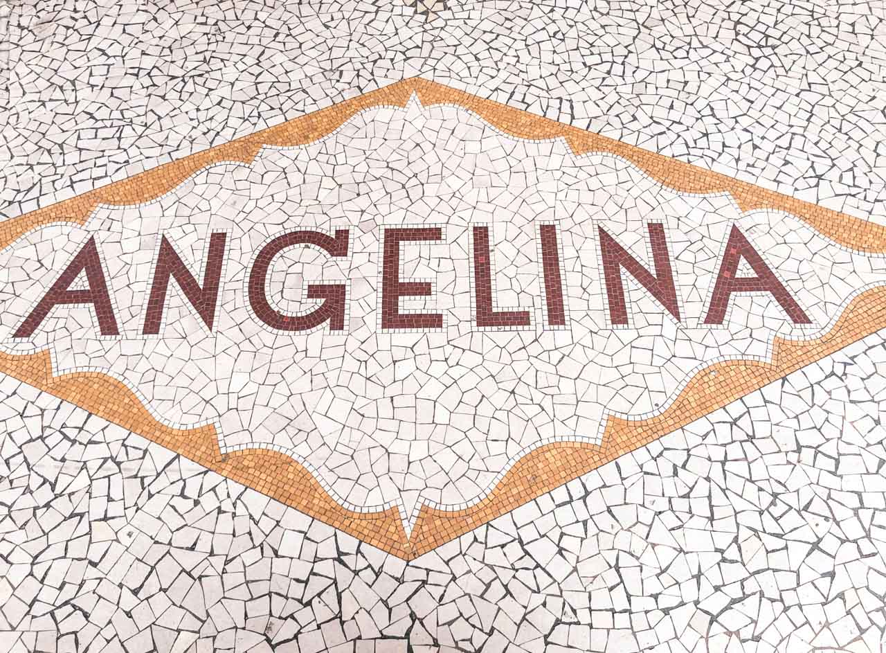 Mosaic tile floor outside the main entrance of the Angelina café in Paris