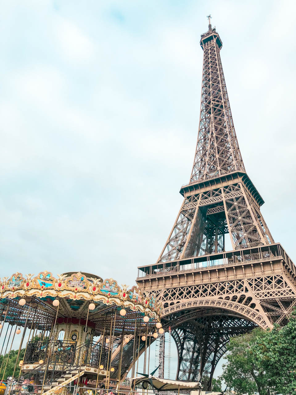 A close-up shot of the Carousel of the Eiffel Tower on the left and the Eiffel Tower on the right