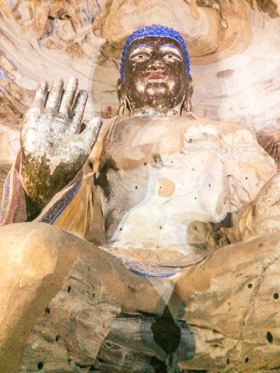A colourful Buddhist statue carved inside a cave at the Yungang Grottoes in Datong, Shanxi