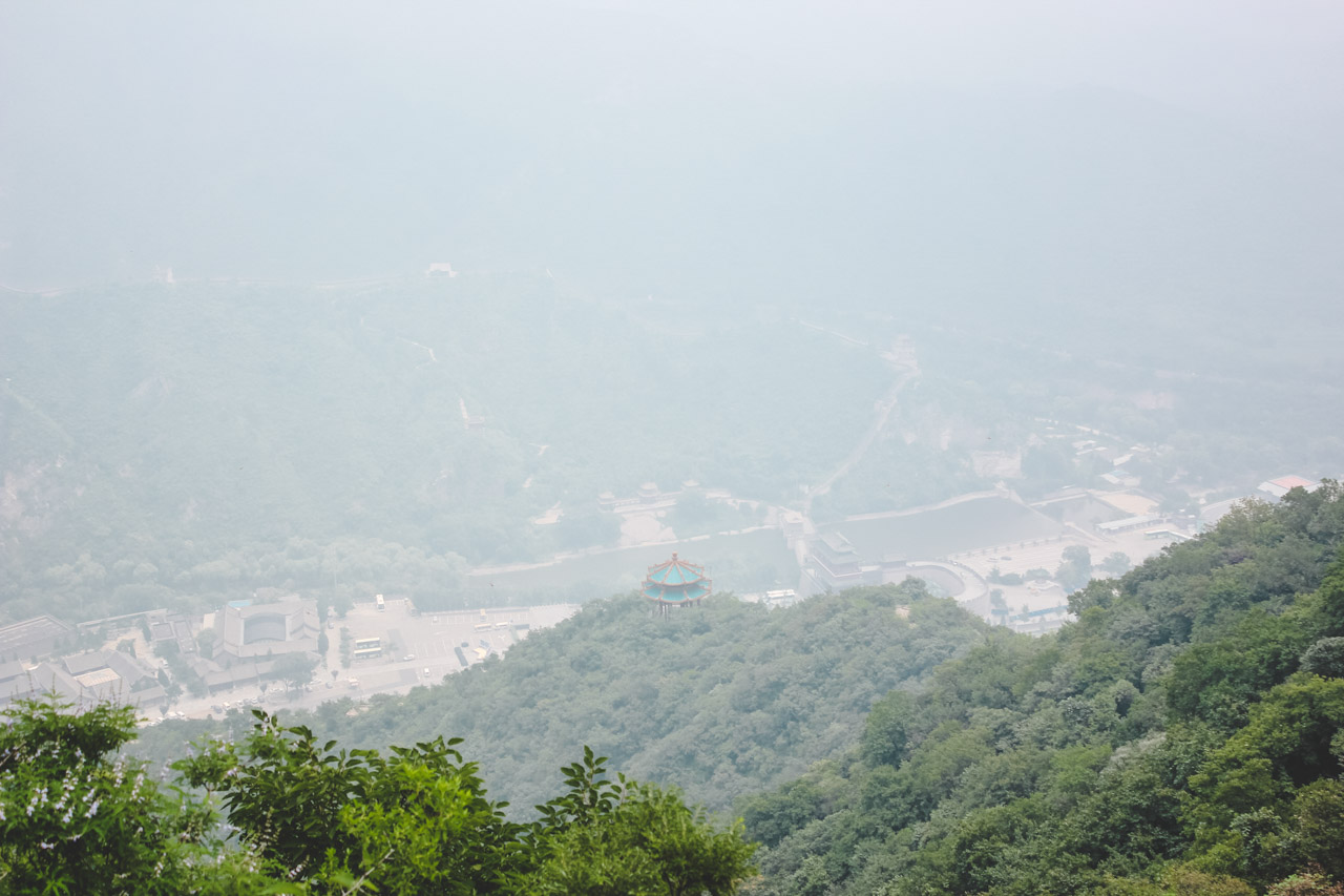 A small fog-covered temple with a blue roof on the Great Wall of China