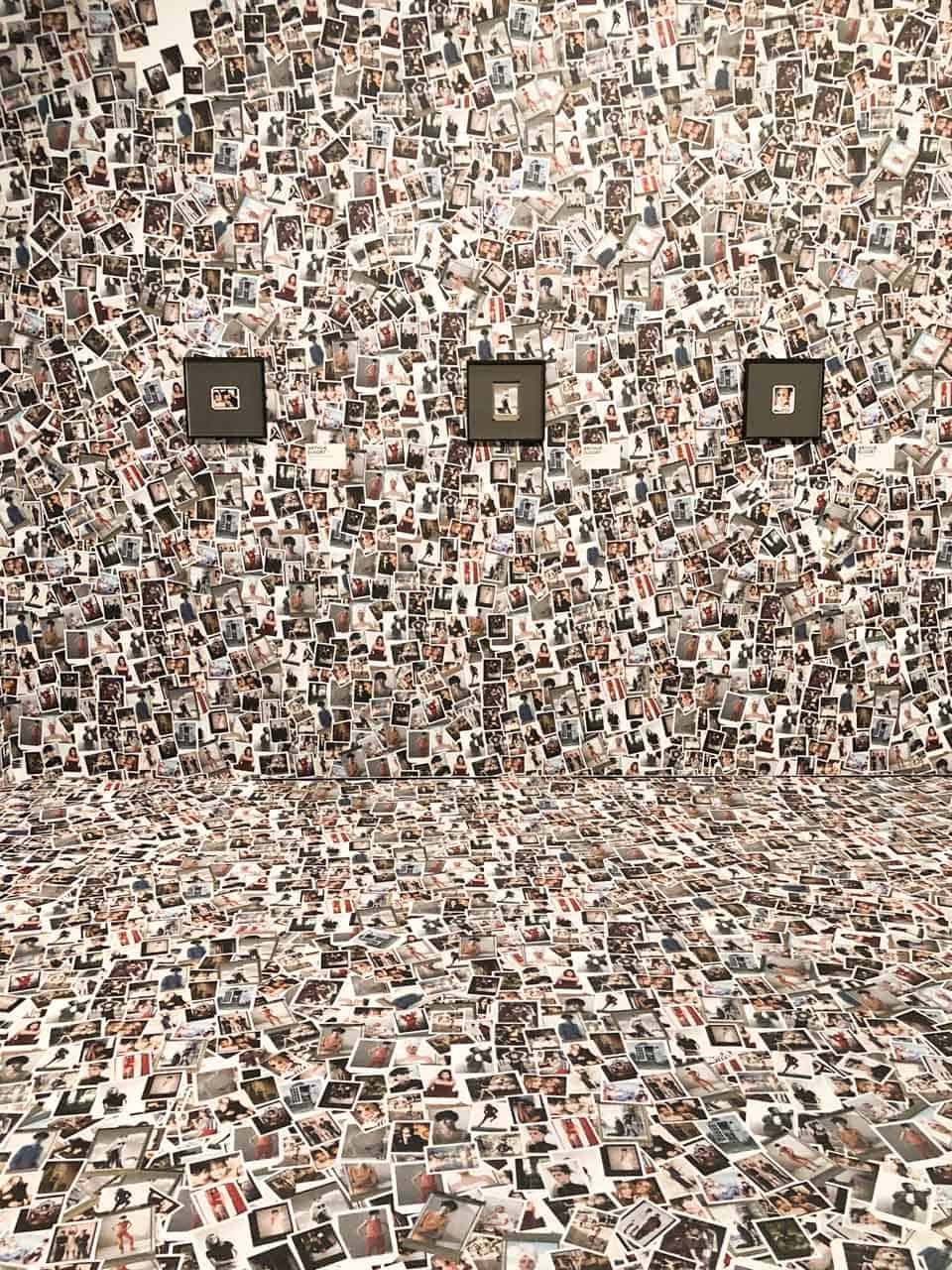 A close-up shot of a room with Polaroid picture stuck to the floor and the walls