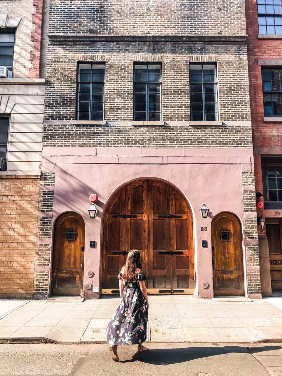 A girl in a maxi dress walking towards Taylor Swift's old apartment on Cornelia Street