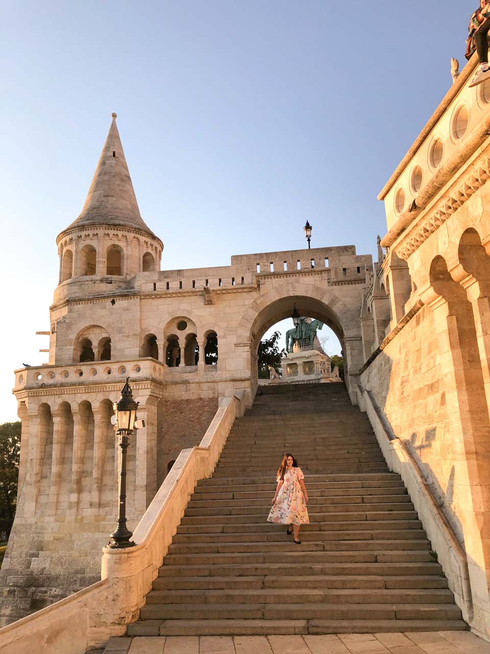 A girl in a maxi dress walking down the stairs of the Fisherman's Bastion in Budapest, Hungary