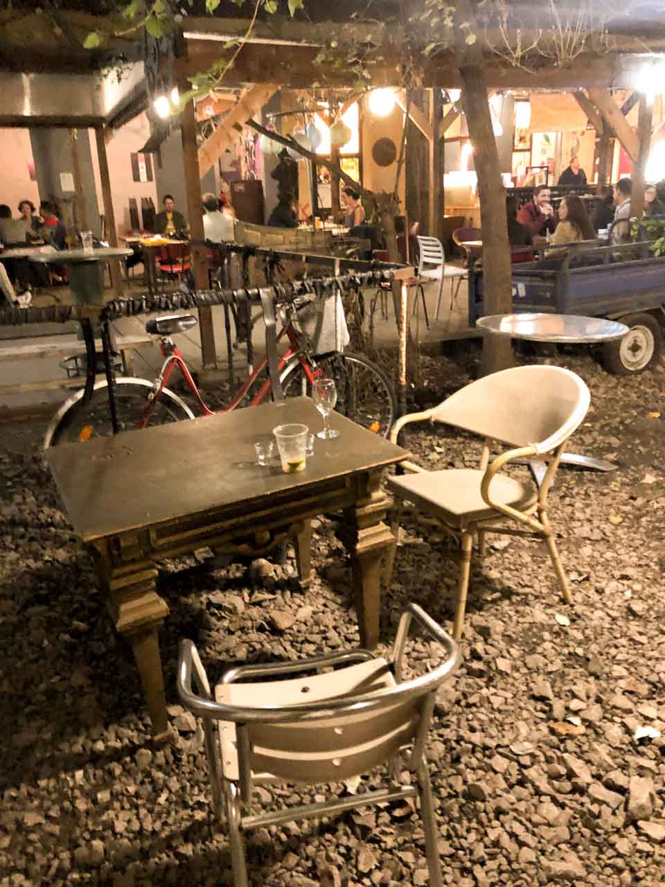 A table with chairs at Grandio Jungle Bar, a ruin bar in Budapest, Hungary