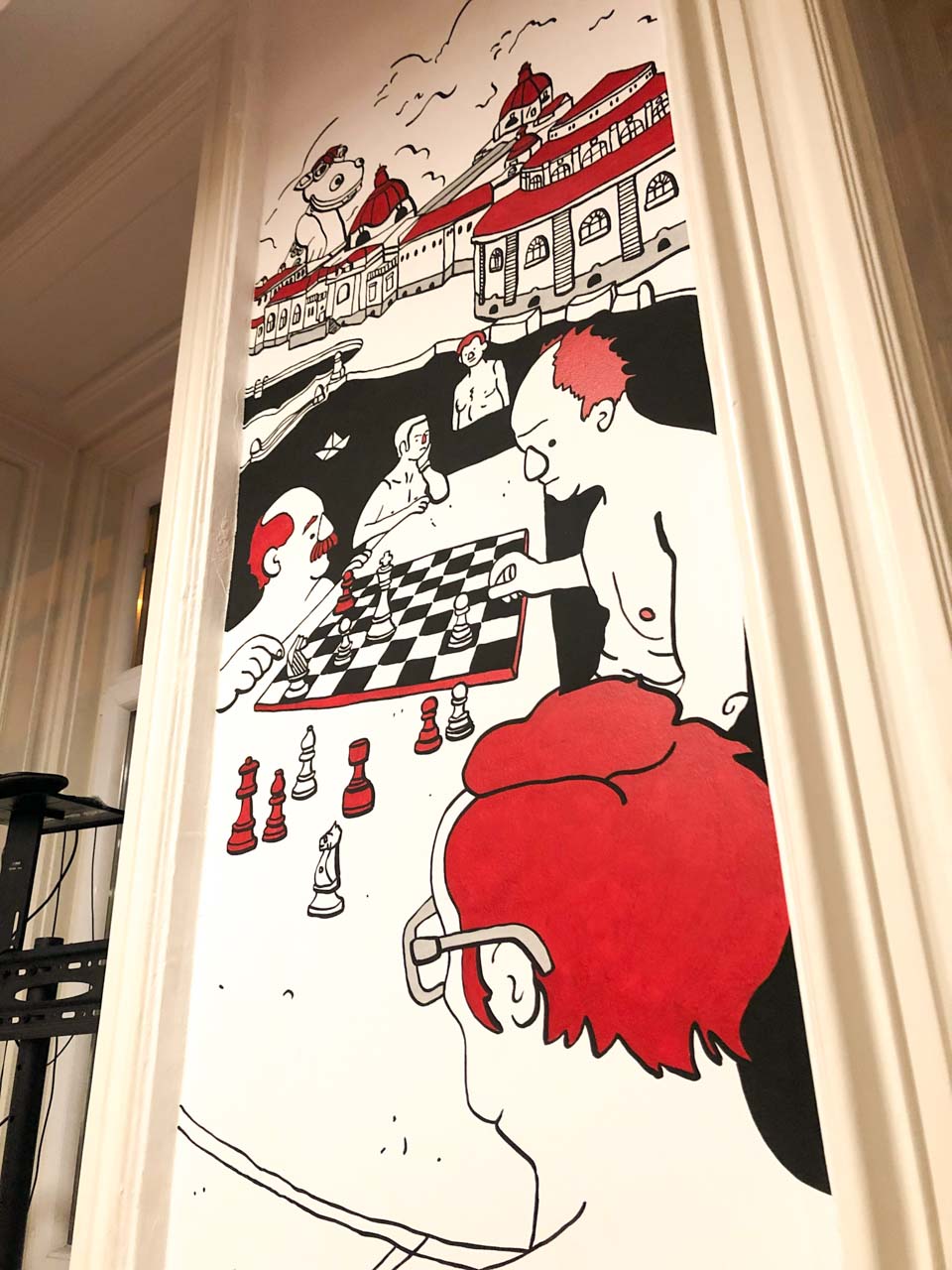 Painting of a group of men playing chess on the wall of Retró Lángos in Budapest