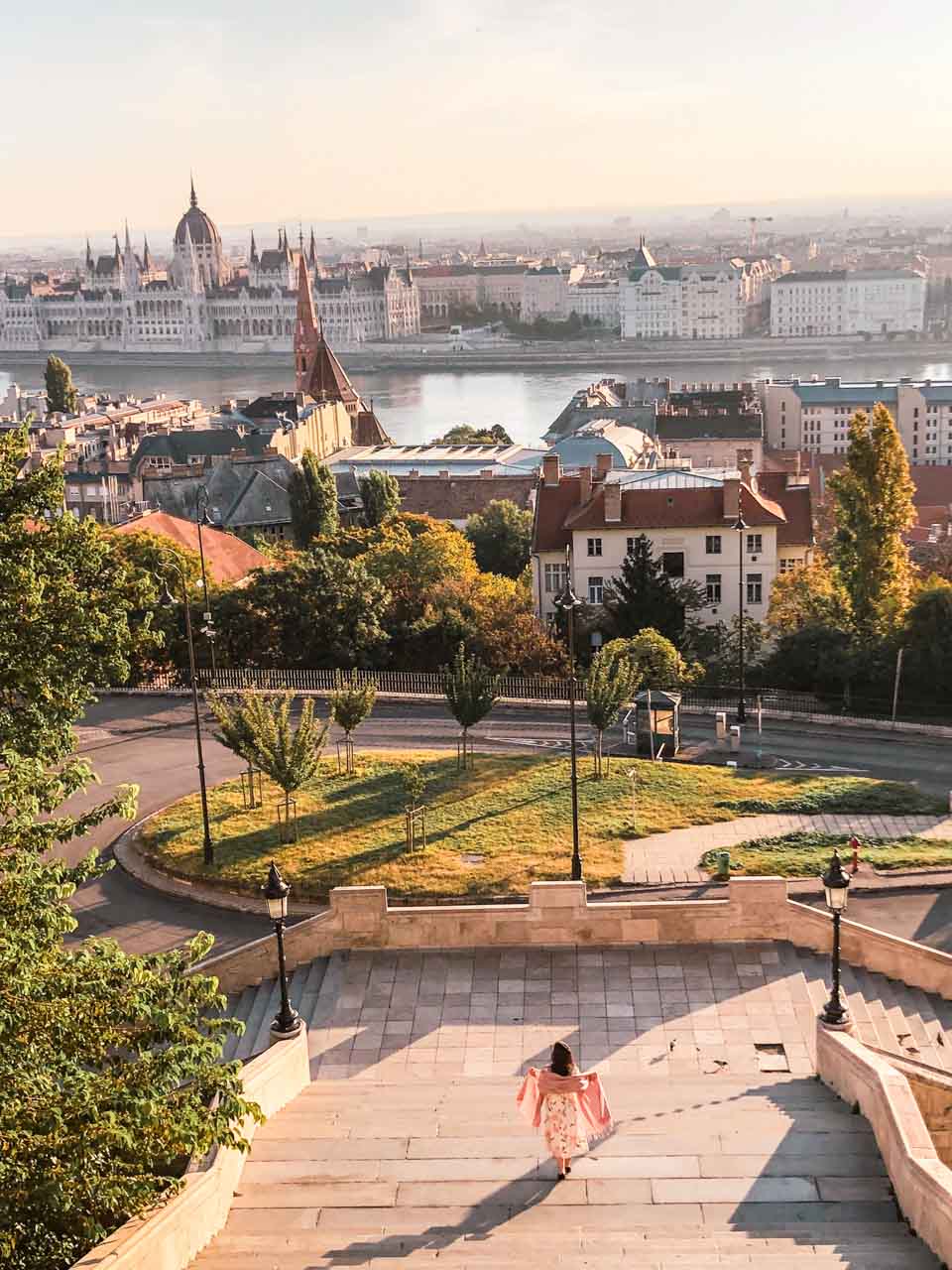A girl down the stairs of the Fisherman's Bastion with the Hungarian Parliament in the background