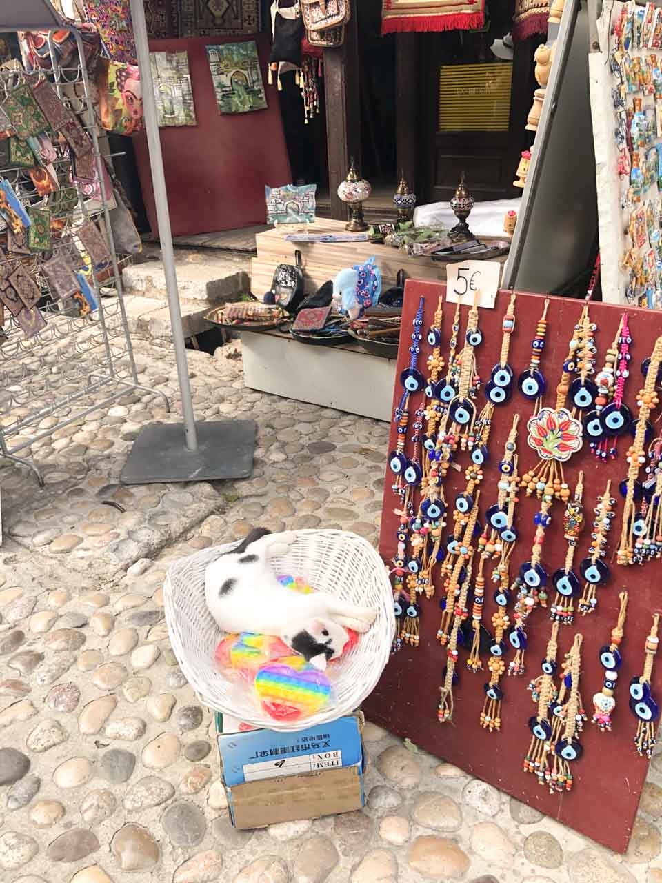 A cat sleeping in a basket outside one of the stalls in Mostar