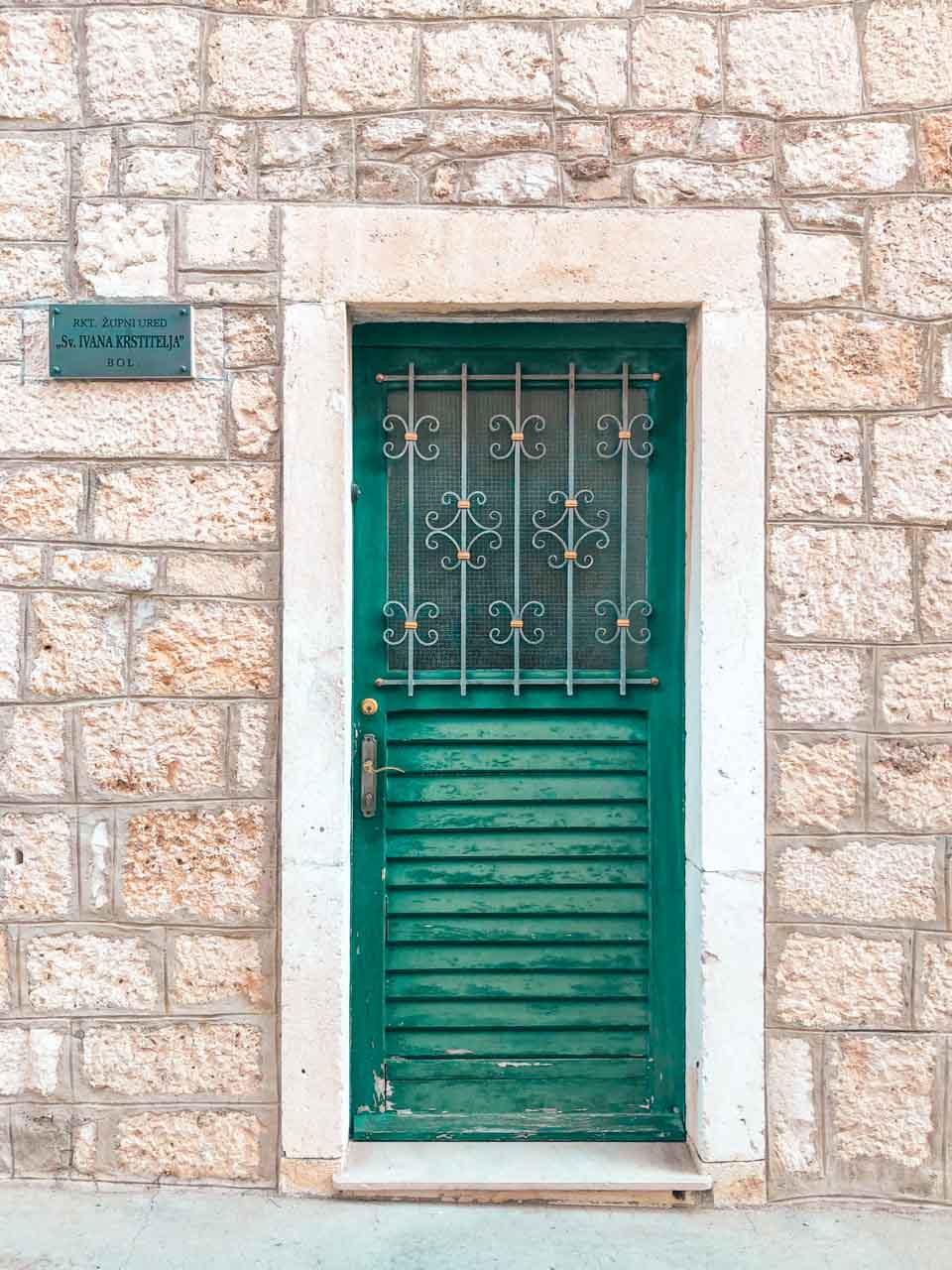 Green door on a stone house in Bol, Croatia