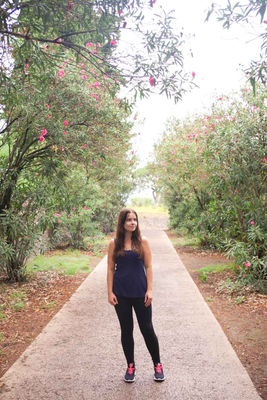 A girl standing between blossoming trees inside the Pompeii Archaeological Park