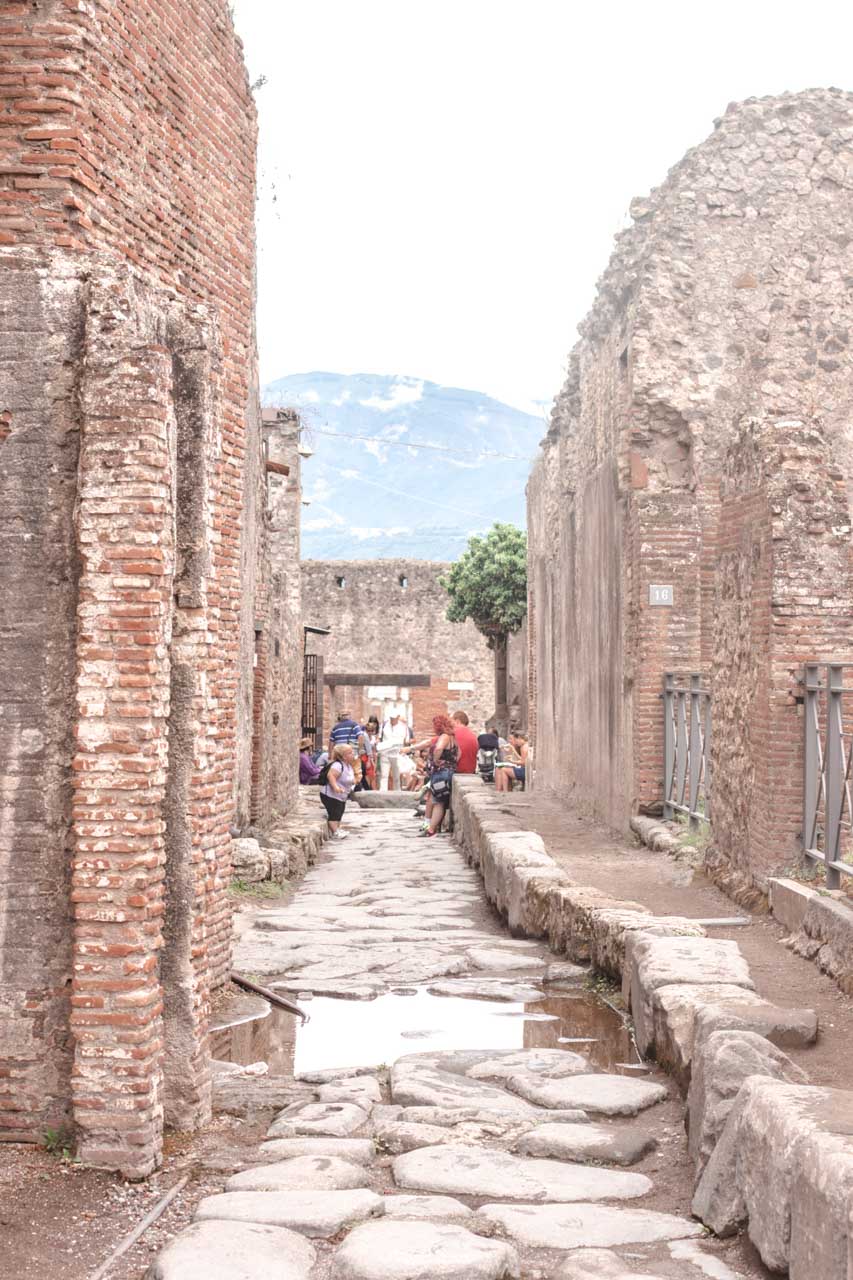 Old ruins in a cobblestone alley of the Pompeii Archaeological Park