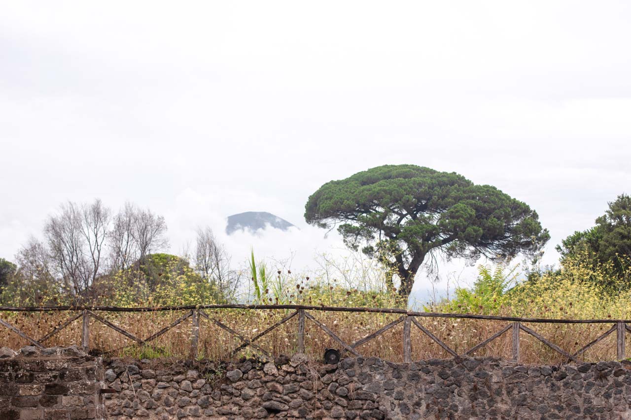 Cloud-covered trees seen from an alley in Pompeii