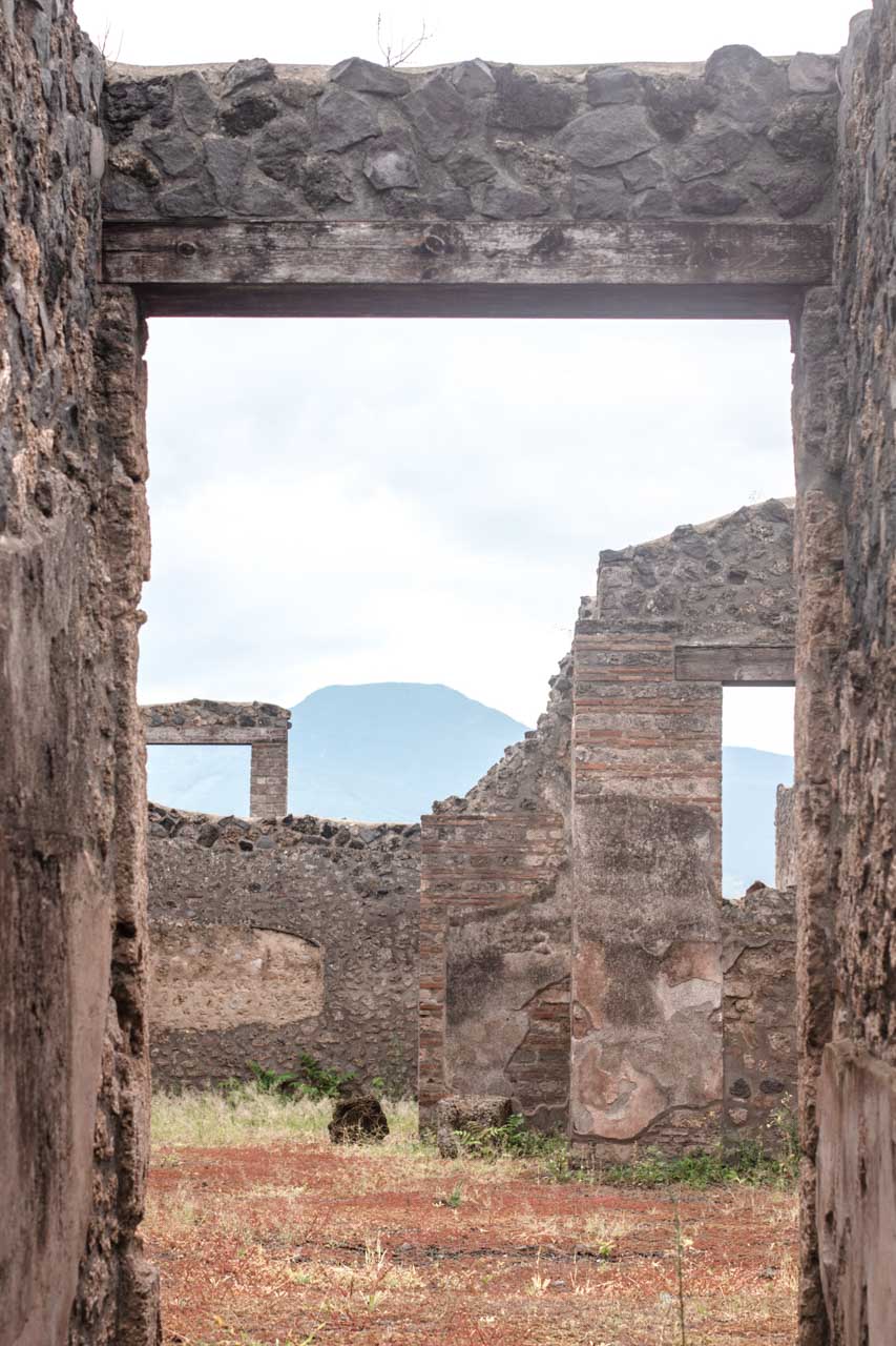 Ruins of Roman doorways inside Pompeii with Mount Vesuvius seen in the distance