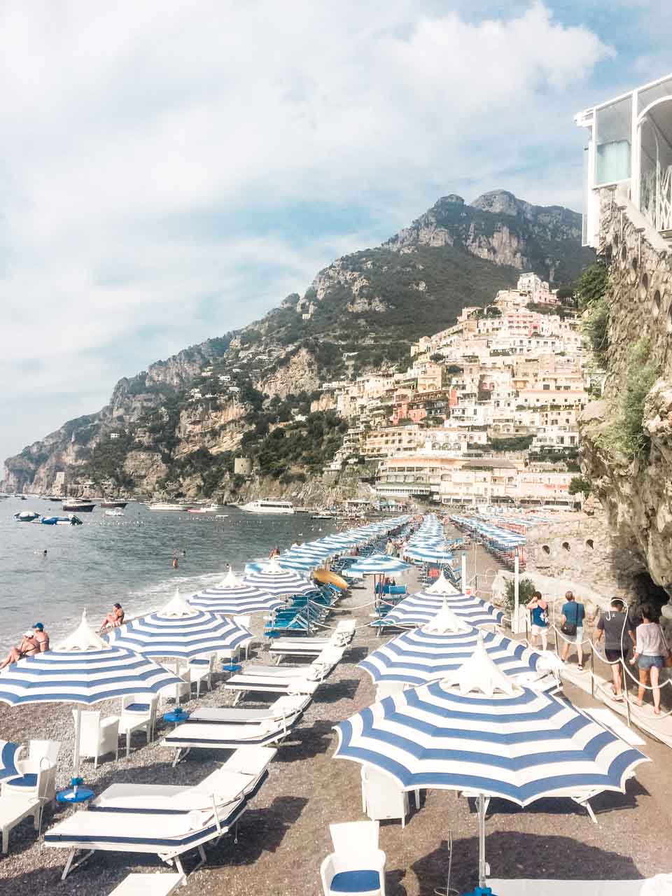 Rows of colourful striped umbrellas on Spiaggia Grande in Positano, Italy seen from above