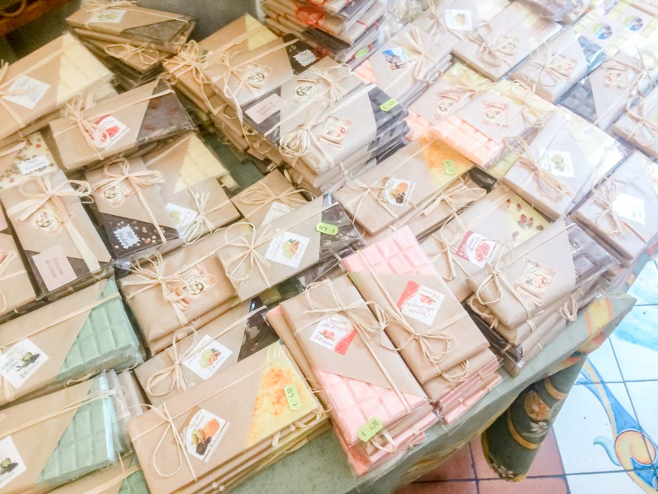 Various chocolate bars in decorative packaging on display at a souvenir shop in Positano, Italy