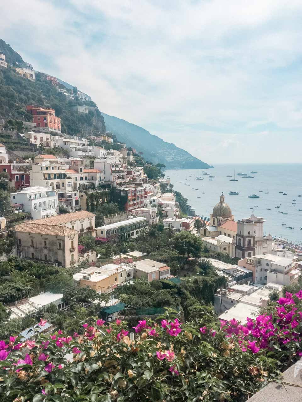 Boats on the sea and hillside houses in Positano, Italy seen from above