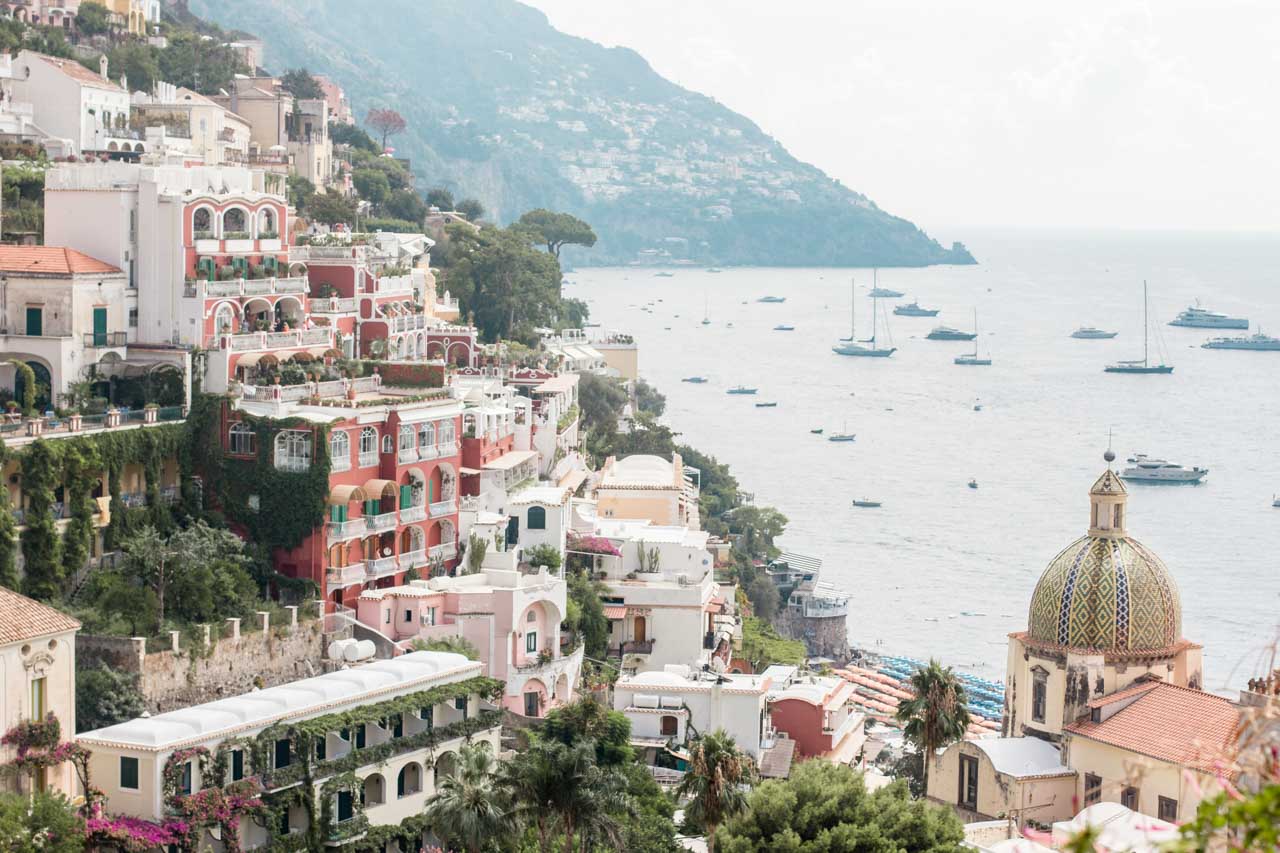 Boats on the sea and hillside houses in Positano, Italy seen from above