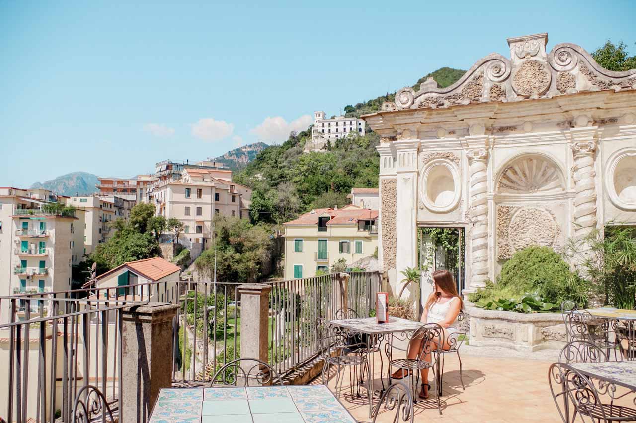 A girl sitting at a table on the terrace of Giardino della Minerva in Salerno, Italy
