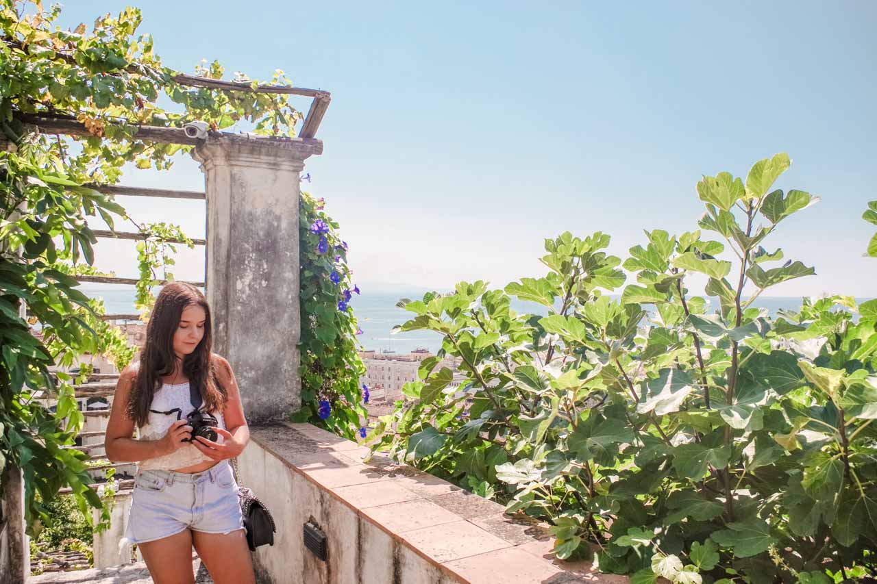 A girl looking at her camera inside Giardino della Minerva in Salerno, Italy