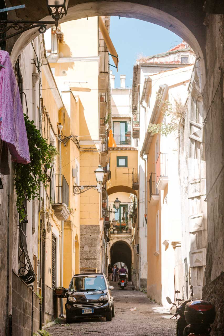 A man riding his scooter in an alley in Salerno, Italy