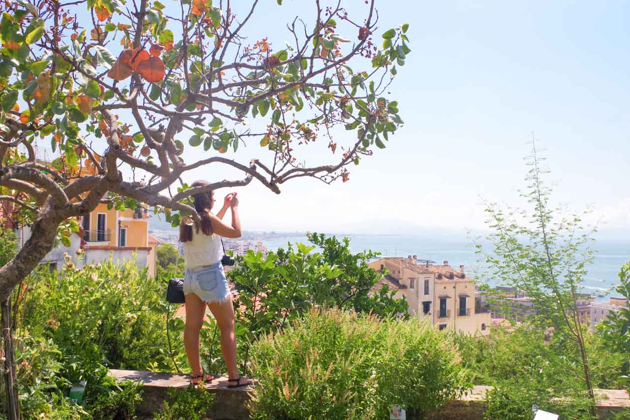 A girl taking a photo inside Giardino della Minerva in Salerno, Italy