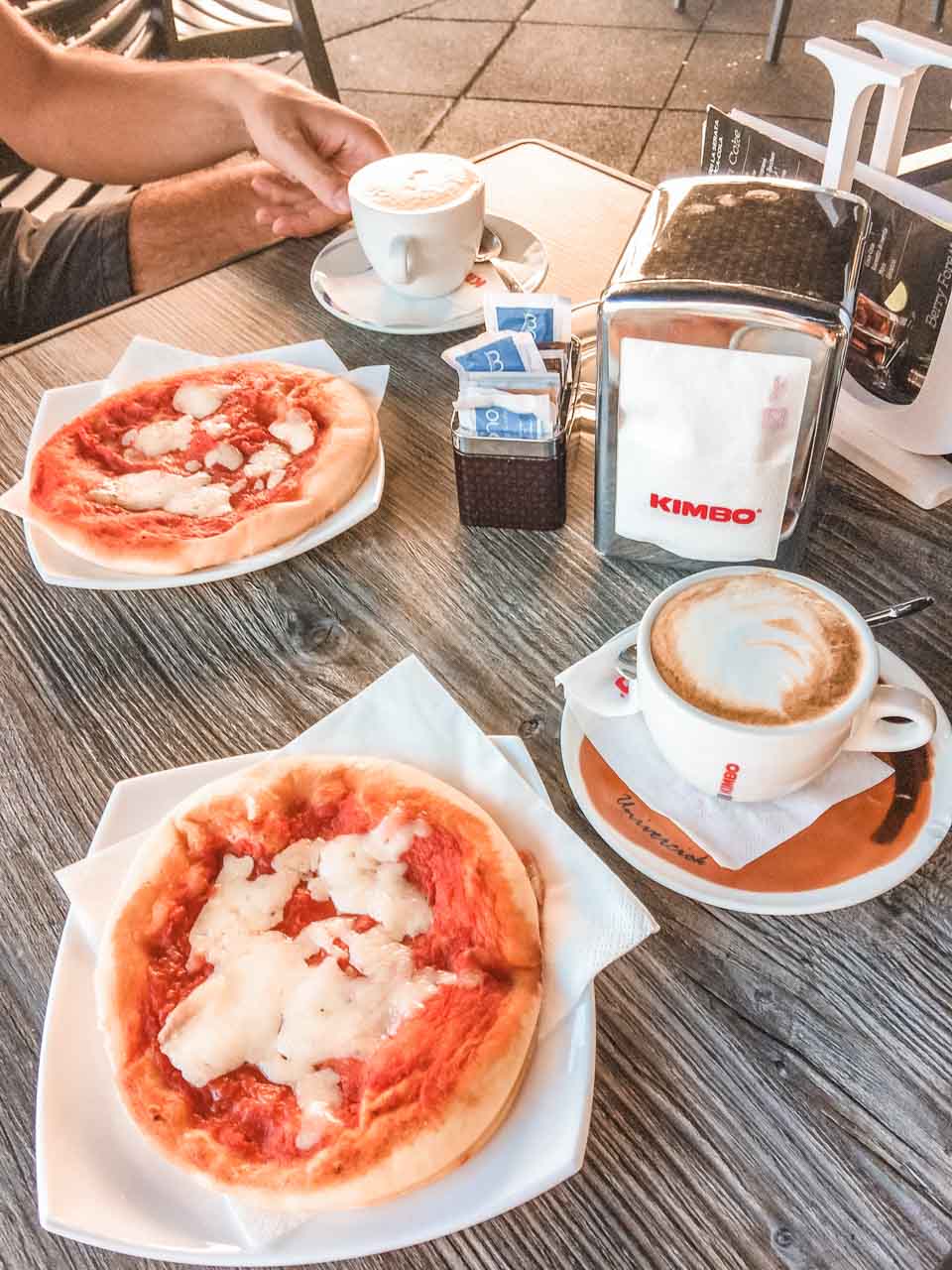 Two mini pizzas and cups of coffee on a table outside Marittimo Bar Tobacco and Coffee in Salerno