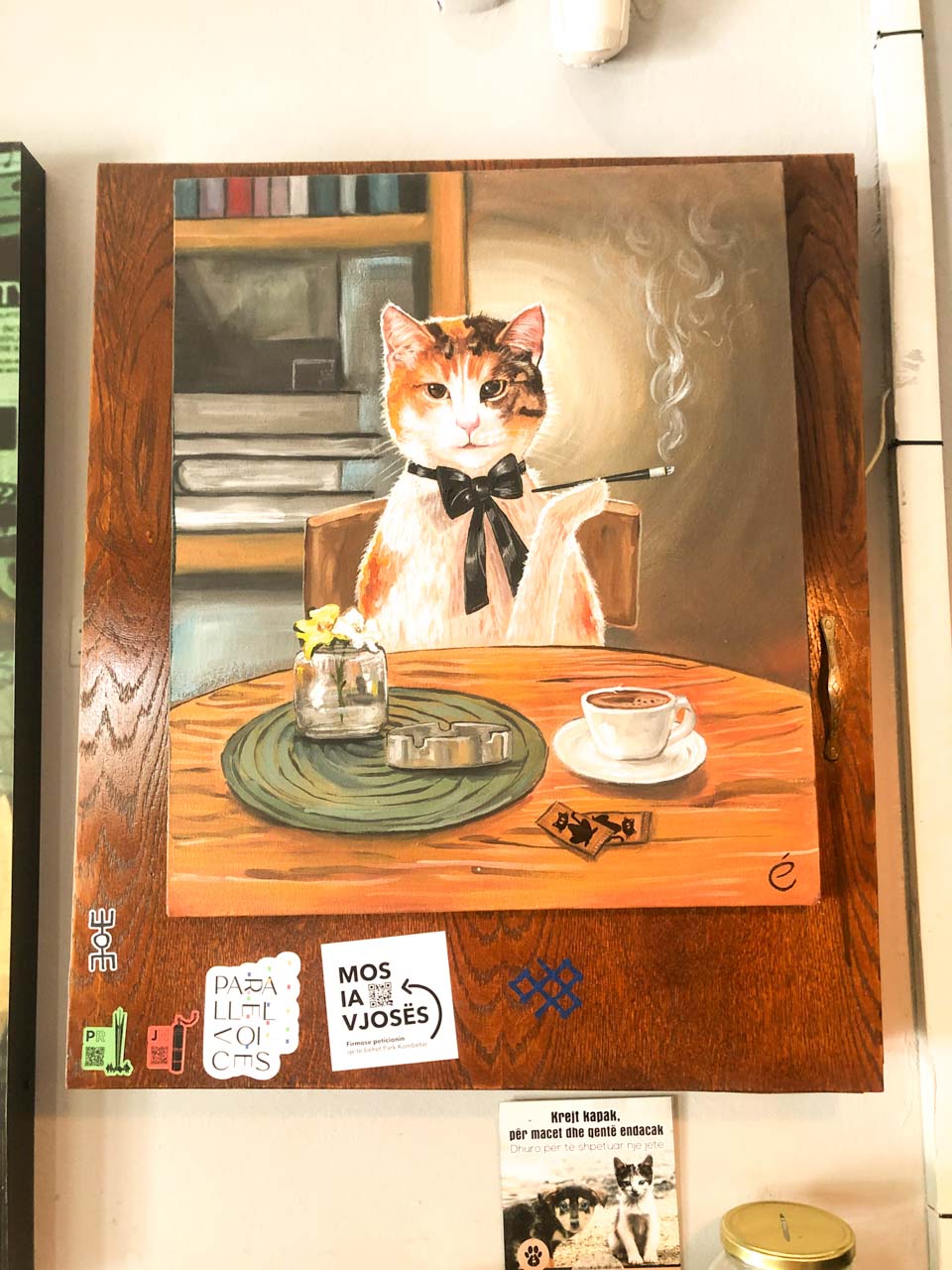 Painting of a cat holding a long cigarette holder on the wall of Dit’ e Nat’ in Pristina, Kosovo