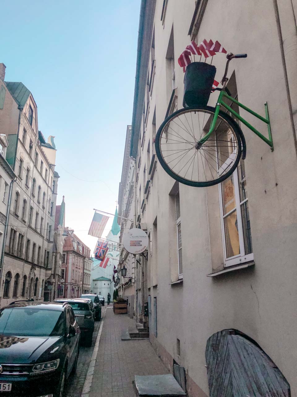 A bike sticking out of a wall in a street of Riga Old Town
