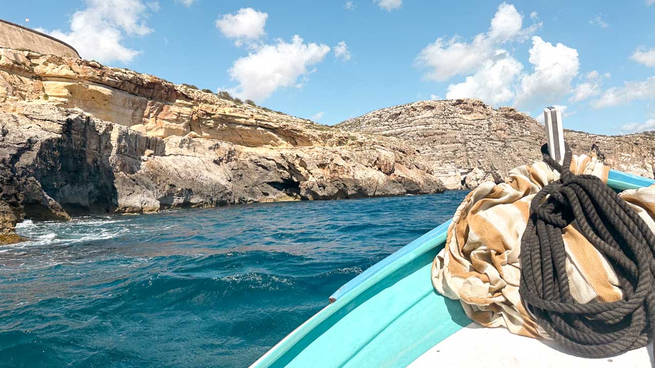 Clear blue water at the Blue Grotto in Malta seen from a boat