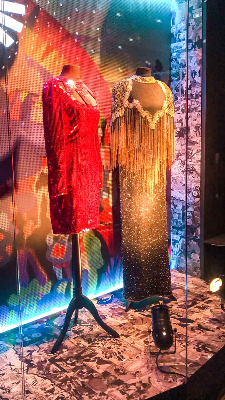 A red and a gold sparkly dress on display at Modes Muzejs in Riga