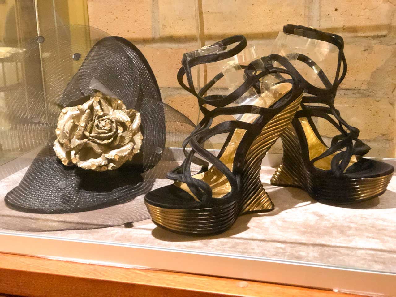 A fascinator hat and a pair of Alexander McQueen shoes on display at the Riga Fashion Museum
