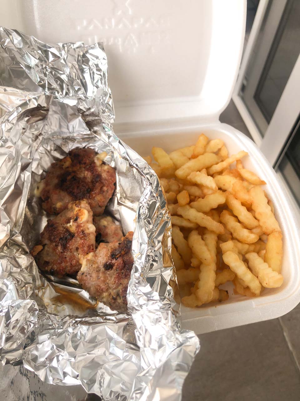 Meat and chips in a takeaway container