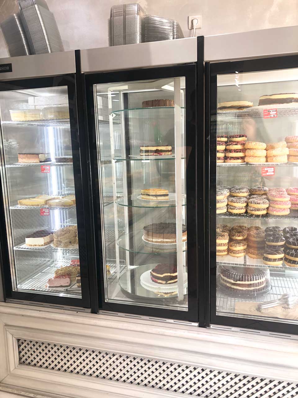 Pastries, donuts, and cakes in a glass display case at Pekara Buongiorno in Kotor, Montenegro