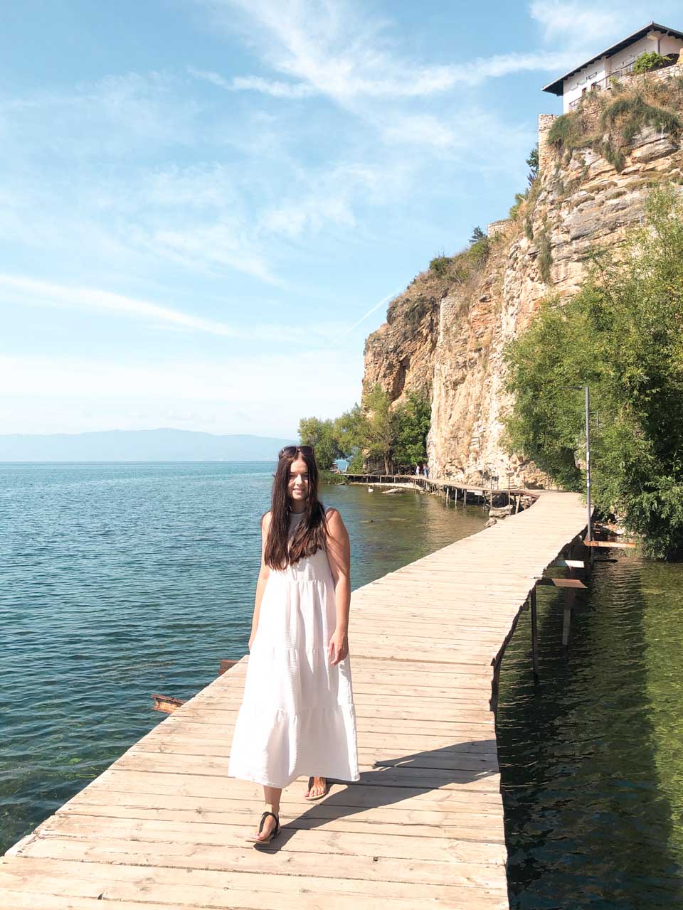 Brunette in a white maxi dress walking on the Ohrid Boardwalk