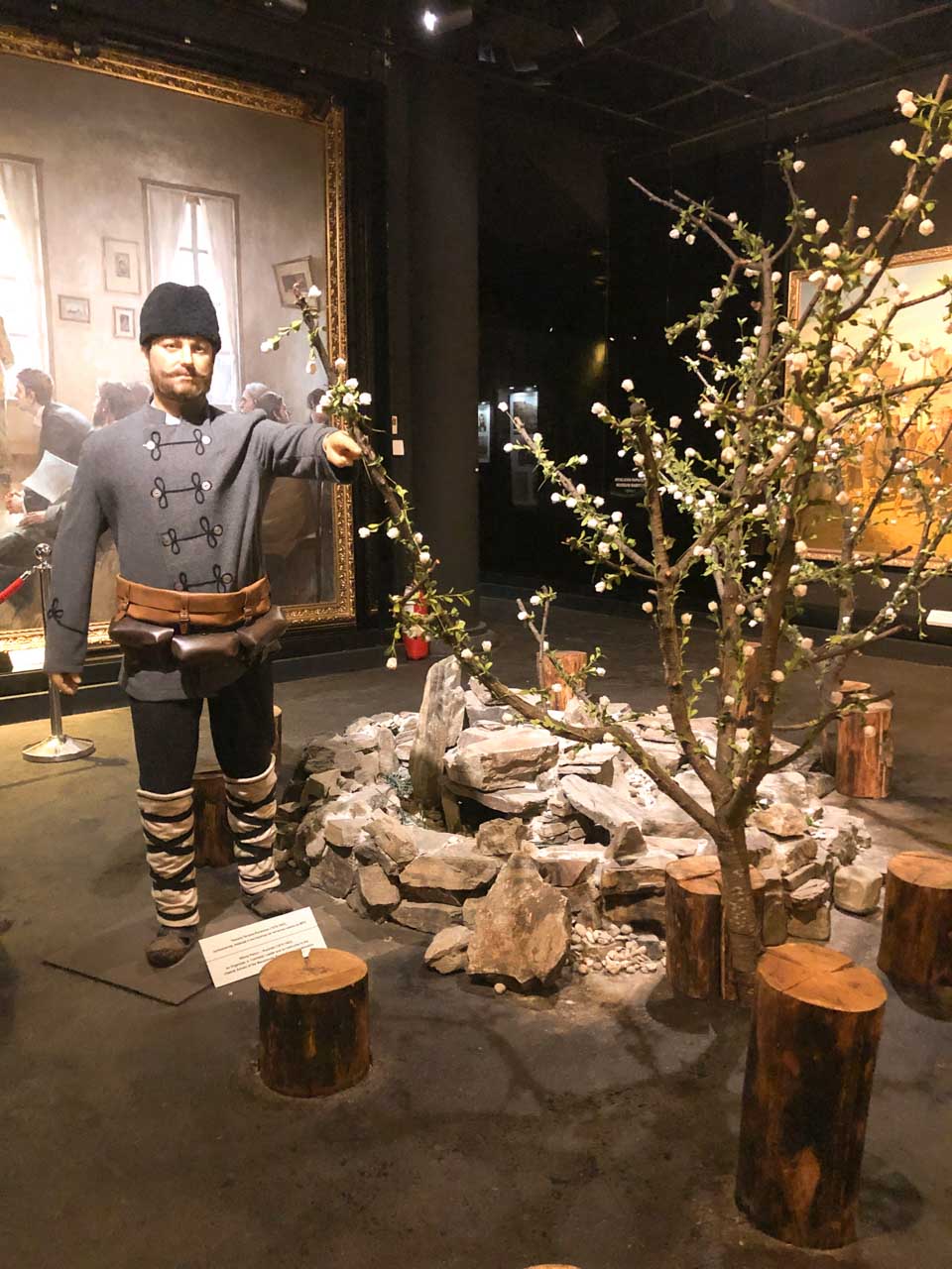 Wax figure of a man standing next to a tree and a fireplace on display at the Museum of the Macedonian Struggle in Skopje