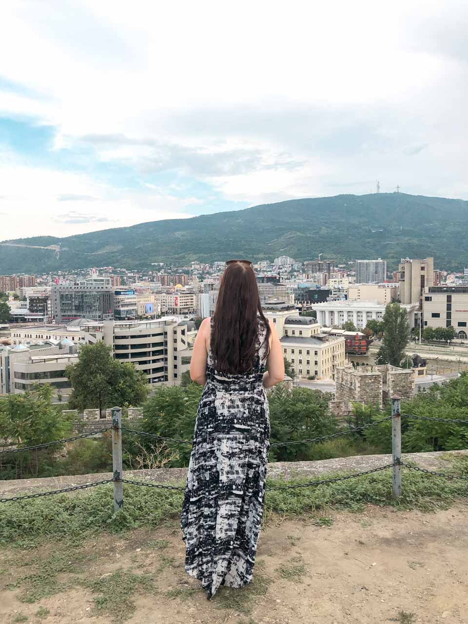 Woman in a black and white maxi dress admiring the panorama of Skopje from the top of the Skopje Fortress