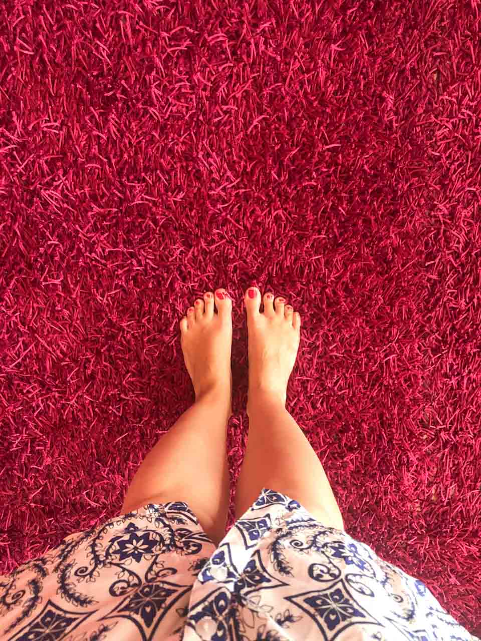 Woman standing barefoot on a pink fluffy carpet