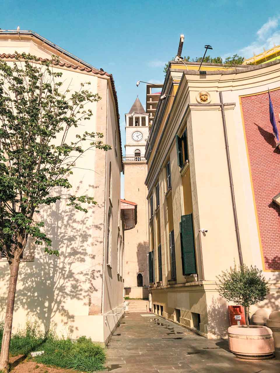 Tirana Clock Tower seen between two buildings on Skanderbeg Square