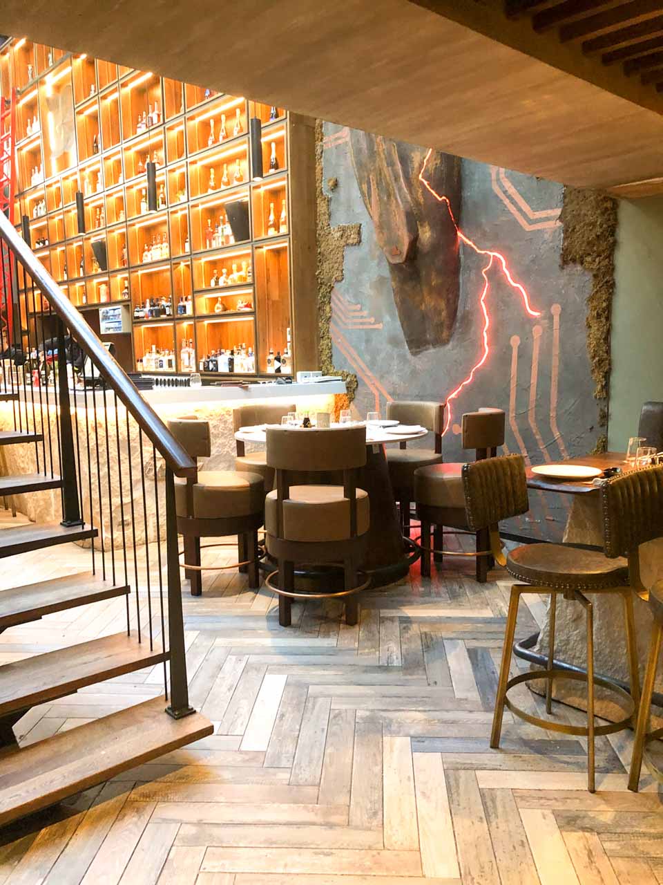 Tables next to the stairs leading to an upstairs seating area at Salt Restaurant in Tirana, Albania